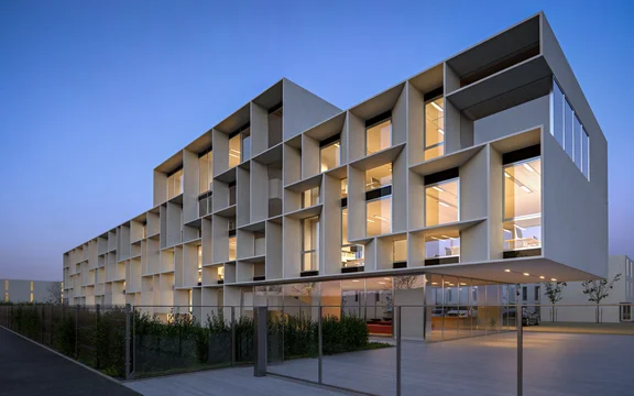 3D Visualization of a modern office headquarters in Italy, featuring a striking façade and illuminated interiors at dusk.